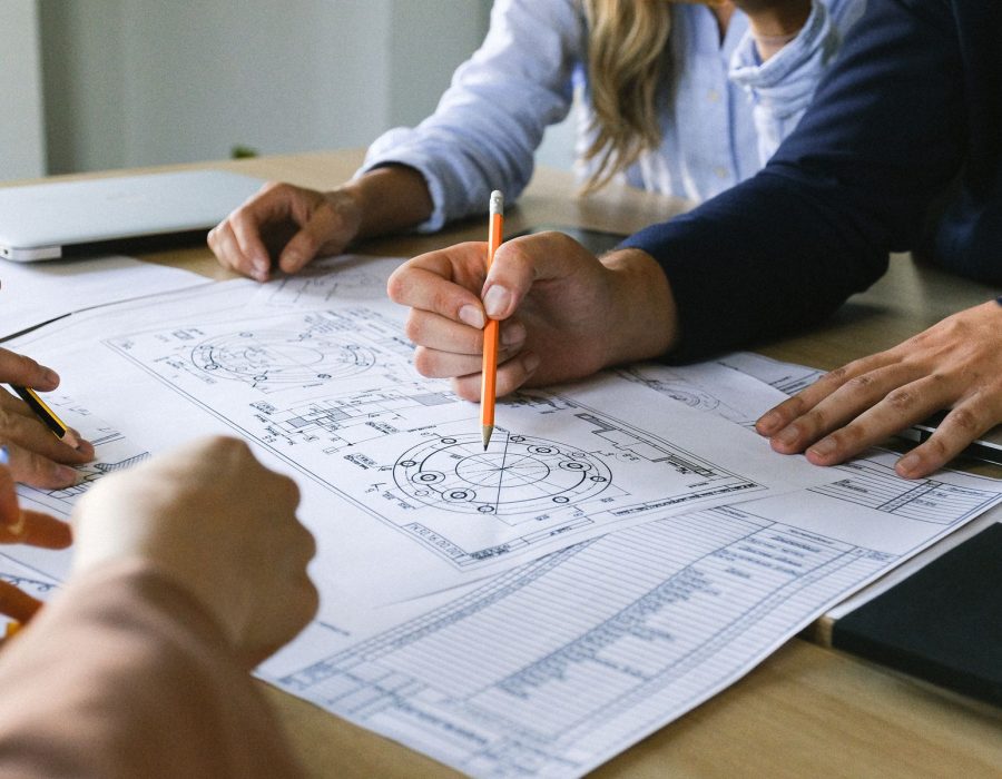Hände mit Bleistift über einem Bauplan